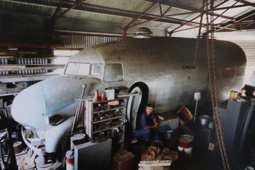 Hull of a plane sitting in a cluttered garage