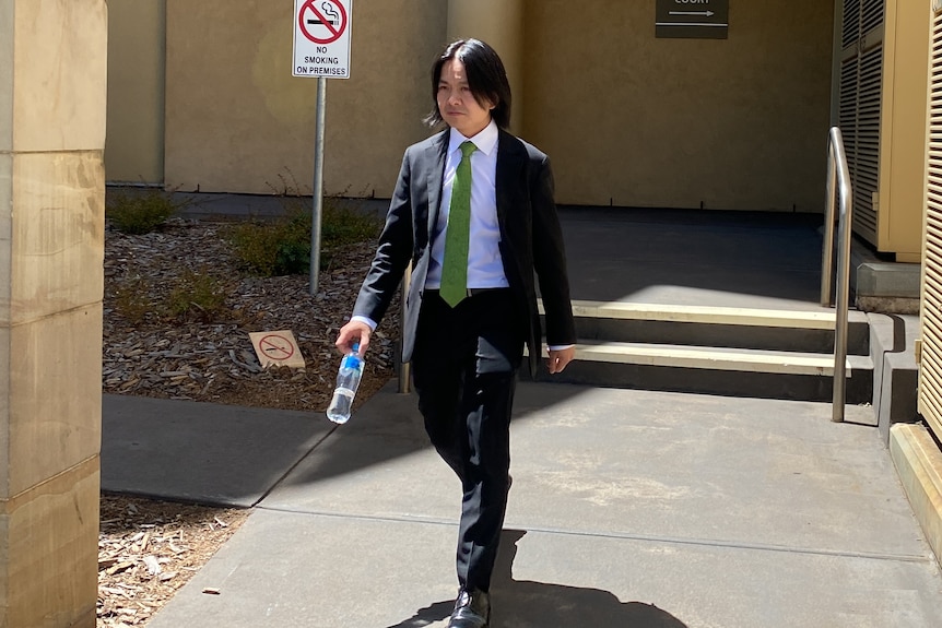 A man wearing a suit walking from a building