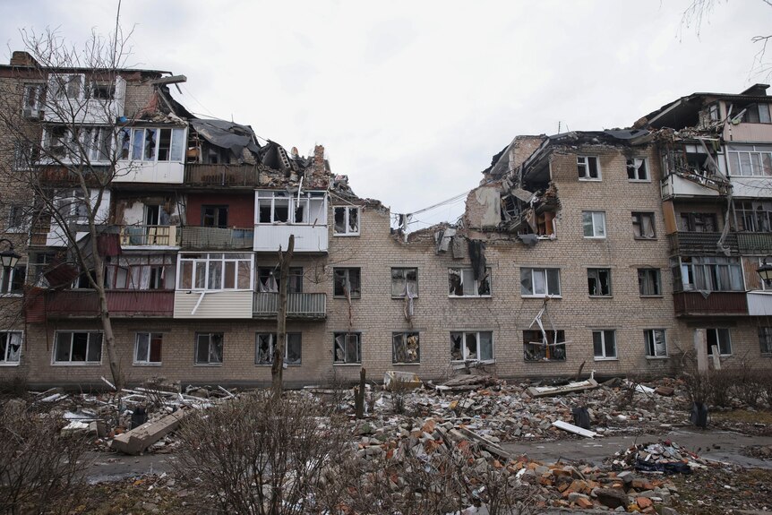 A block of flats with the top storeys missing after it was hit by artillery.