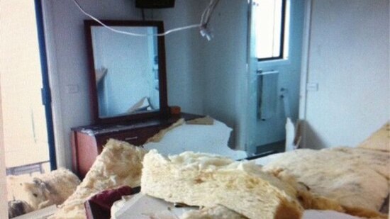Ceiling materials on a bed in a house damaged by a freak storm in Kiama