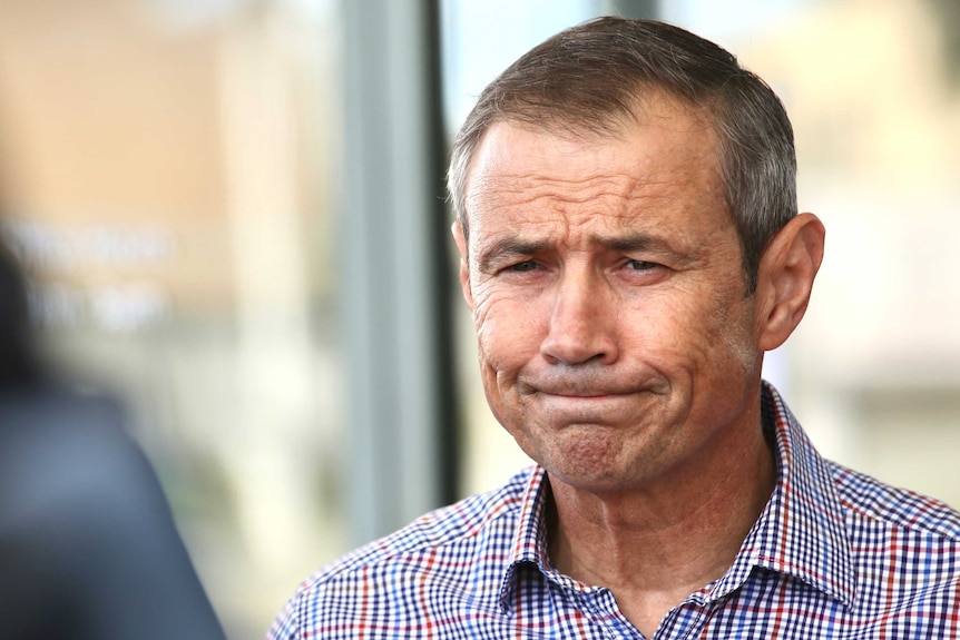 Health Minister Roger Cook frowns and grimaces slightly as he stands outside Mark McGowan's office.