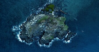 An aerial shot of a small rock island