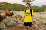 Athlete and running coach stands in front of camera in outback Australia setting.