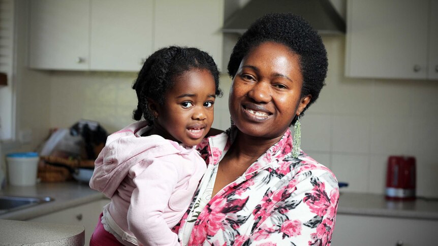 A woman holds her small daughter