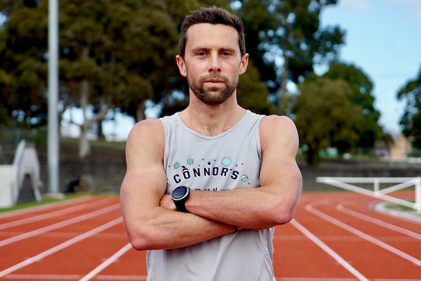 Leigh Chivers stands on a running track.