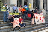 A group of protestors wearing facemasks with signs that read No Nuclear waste dump for SA, Call to Action and No waste dump
