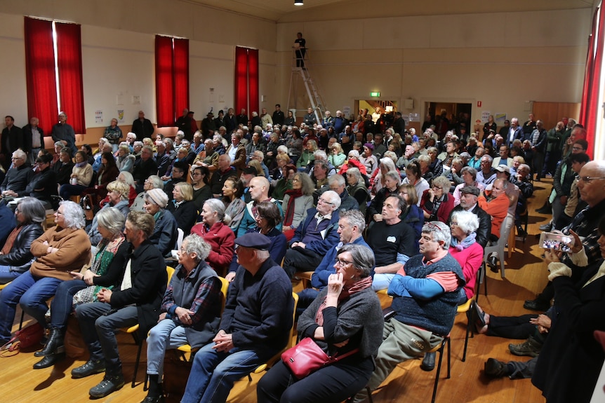 A hall packed with seated people