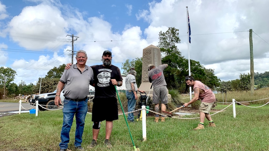 Men work to clean a war memorial.