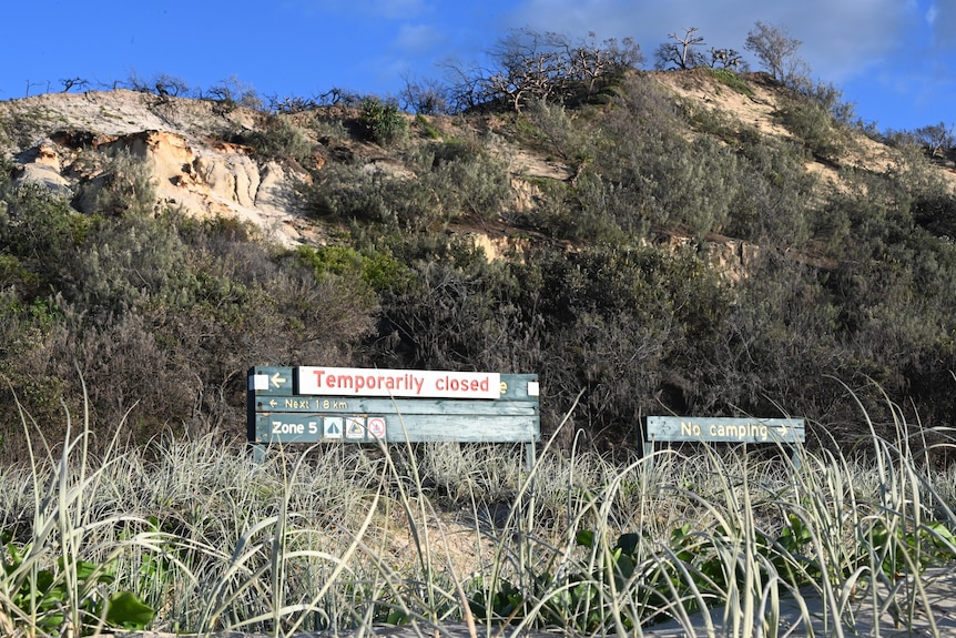 A sign across a campground sign says "temporaily closed".