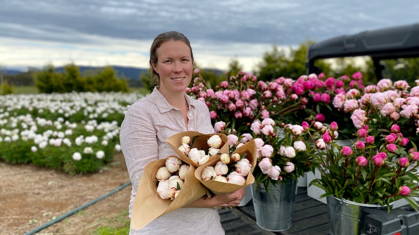 Andrea stands with flowers in her hands