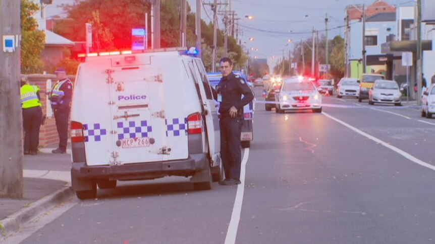 Police stand in front of a police car at the scene of a fatal hit-run in West Footscray.