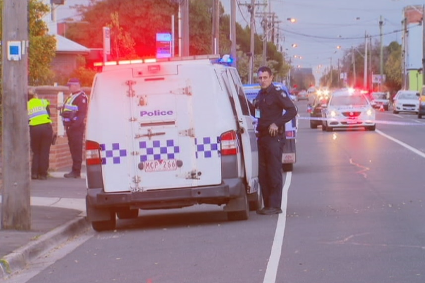 Police stand in front of a police car at the scene of a fatal hit-run in West Footscray.