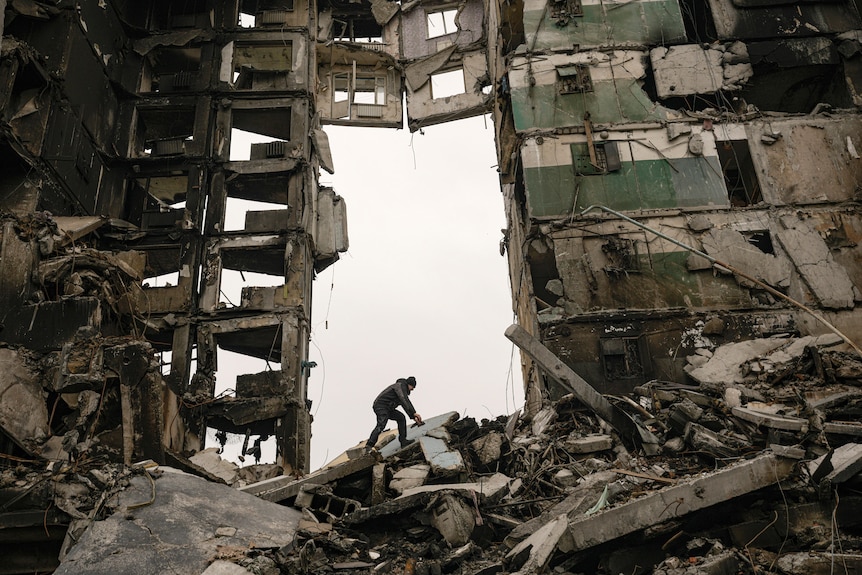 A resident looks for belongings in the ruins of an apartment building destroyed during fighting.