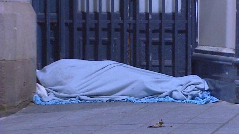 Generic TV still of homeless person under blanket in Brisbane street in south-east Qld.