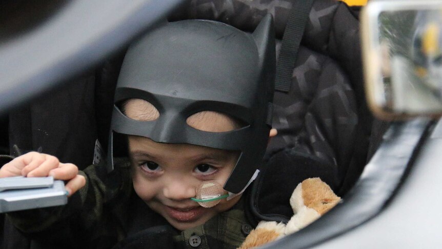 Eli Vale in the Batmobile wearing his Batman mask