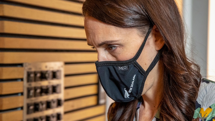 New Zealand Prime Minister Jacinda Ardern wearing a black face mask which reads New Zealand
