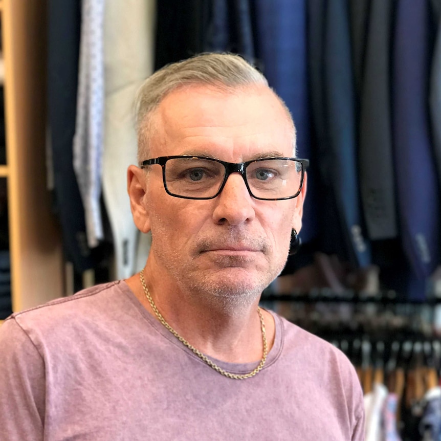 Gray-haired man in a clothing store.