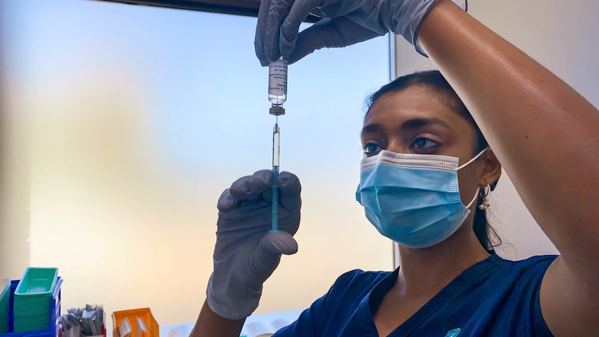 Nurse holding a syringe and vial 