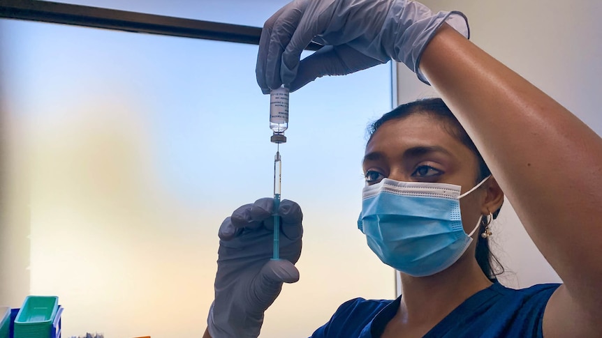 Nurse holding a syringe and vial 