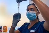 Nurse holding a syringe and vial 