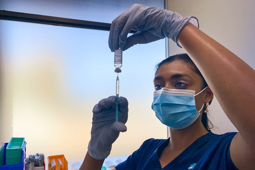 Nurse holding a syringe and vial 