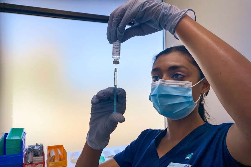 Nurse holding a syringe and vial 