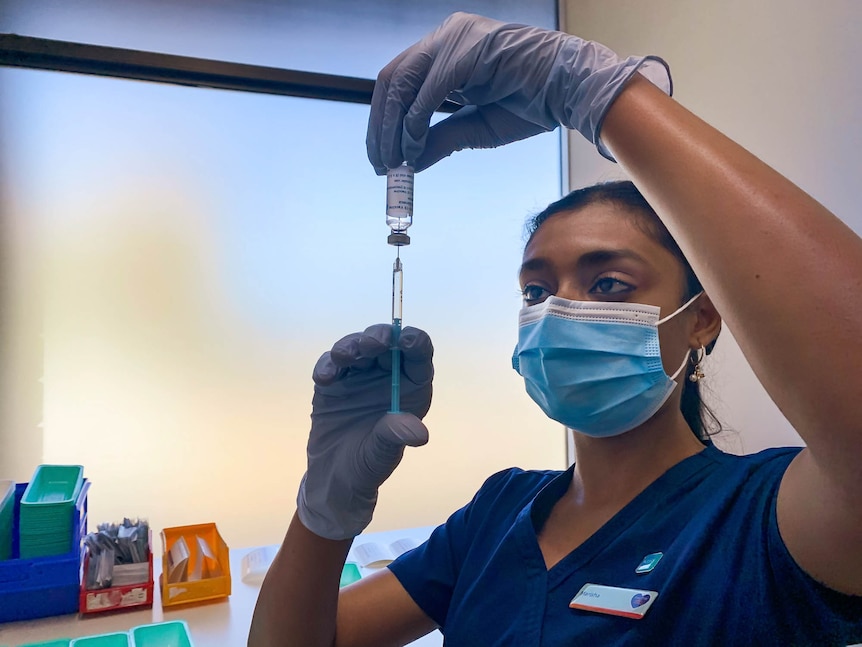 Nurse holding a syringe and vial 