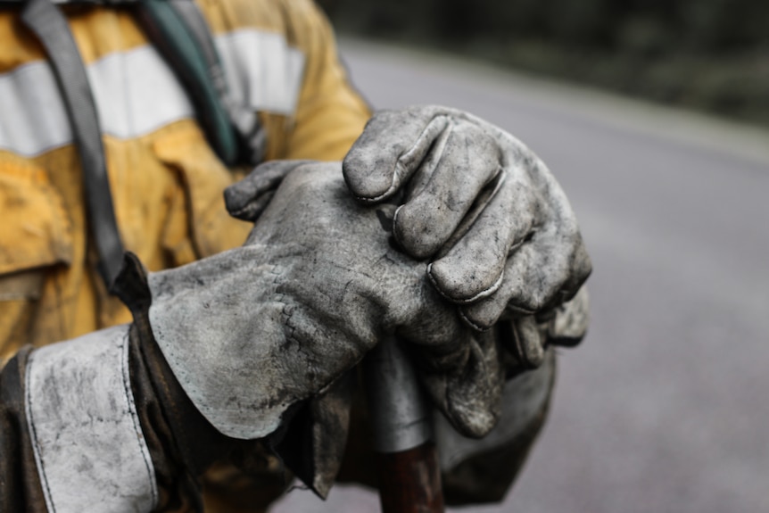 Blackened white gloves resting on top of a rake during the Tasmanian bushfires in 2016.