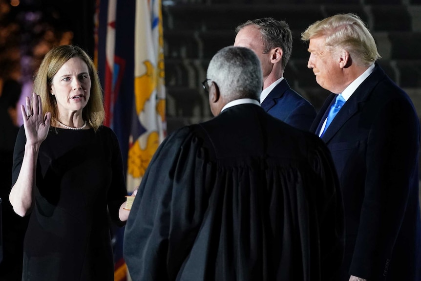 Amy Coney Barrett takes an oath with her hand raised