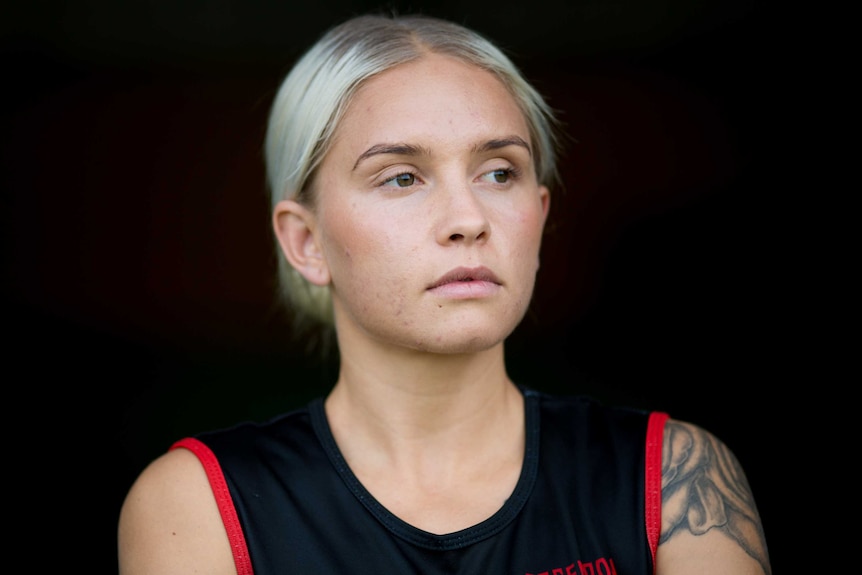 A portrait of Courtney Ugle in her Essendon Football Club colours.