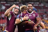 Rugby players in maroon celebrate.