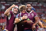 Rugby players in maroon celebrate.