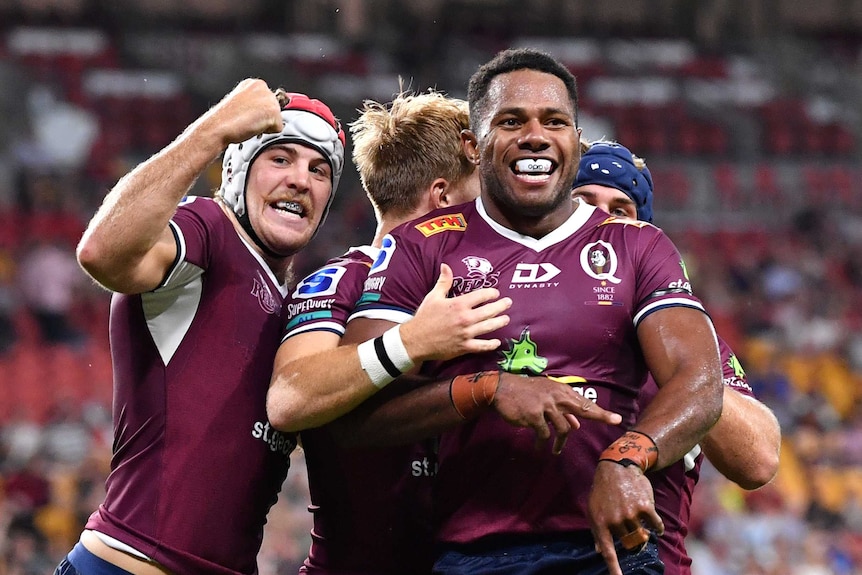 Rugby players in maroon celebrate.