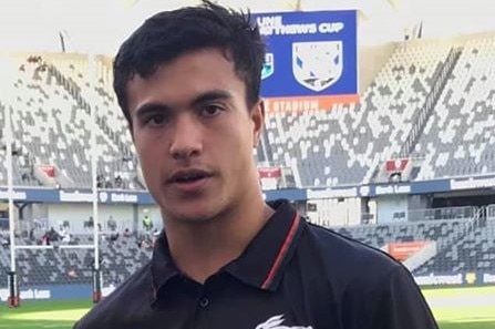 A South Sydney junior rugby league player holds a trophy as he looks at the camera at Western Sydney Stadium.