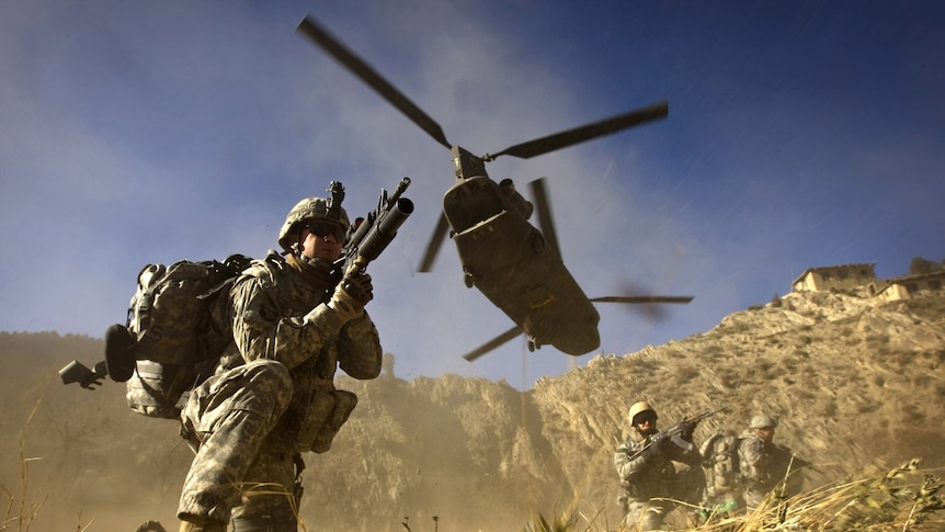 Chinook flies over soldiers