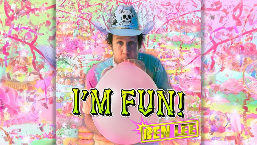 Ben Lee blows into a pink balloon while wearing a blue cowboy hat with a skull. The background is bright rainbow colours.