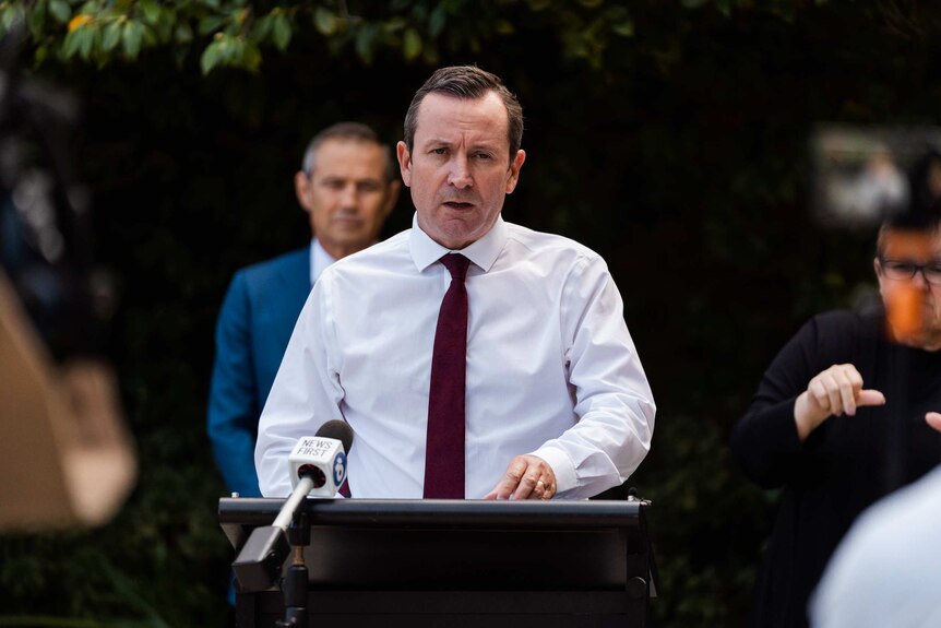 Mark McGowan stands at a podium speaking to the media.
