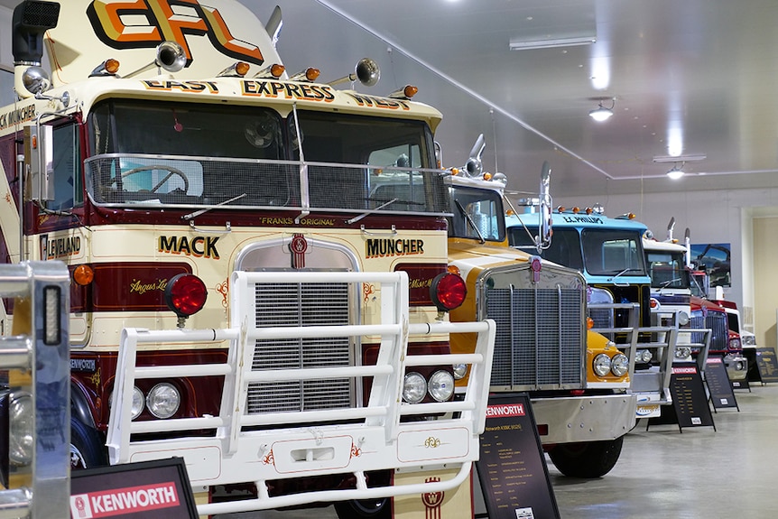 Road trains lined up in a large shed