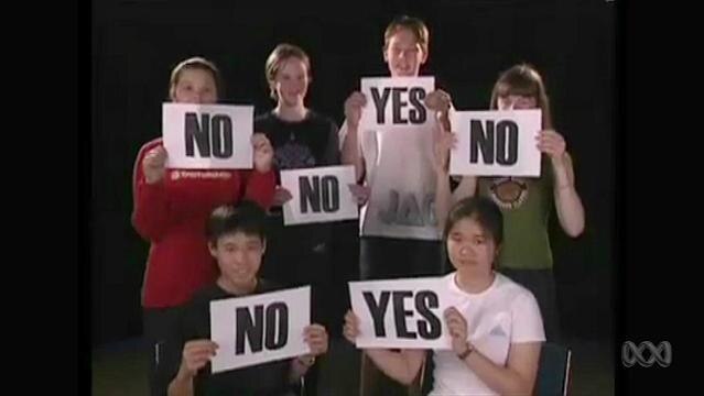 Six teenagers hold signs of either 'yes' or 'no'