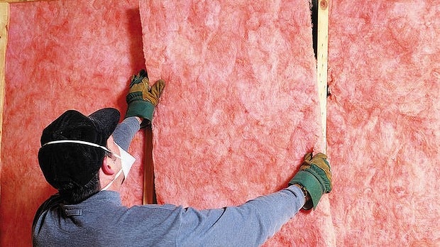 A man installs roof insulation