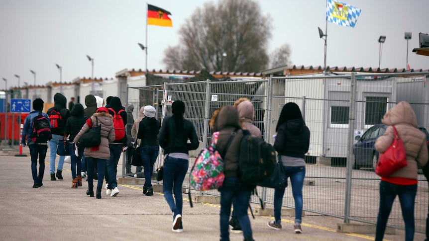 Asylum seekers walk at a registration camp in Erding near Munich.