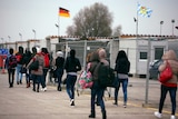 Asylum seekers walk at a registration camp in Erding near Munich.