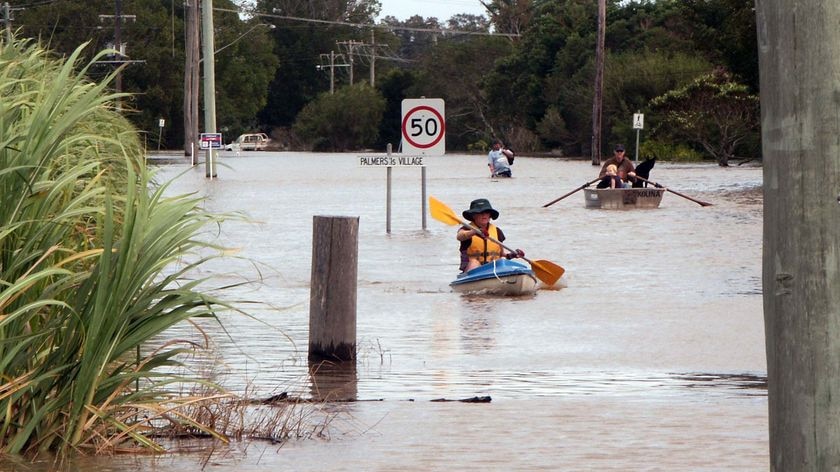 Residents paddle through Yamba floodwaters