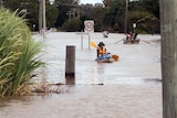 Residents paddle through Yamba floodwaters