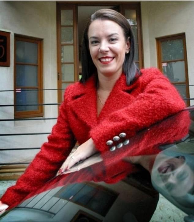 A woman smiles at the camera in a red jacket.