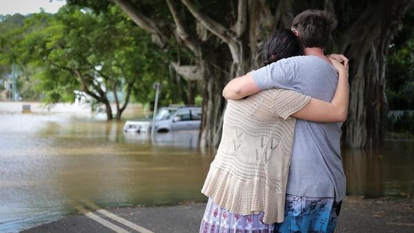 Two people hug as they watch floodwaters in Lismore on March 31, 2017.