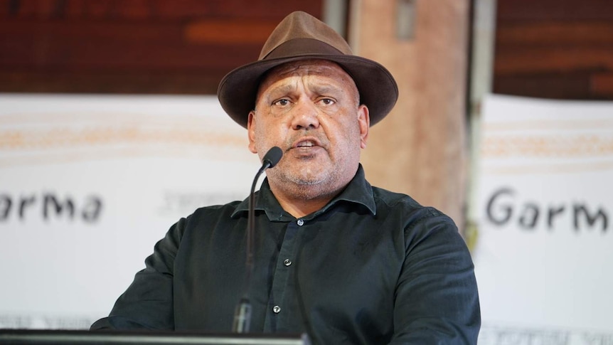 Noel Pearson, wearing a brown hat, speaks at a lectern at a Garma Festival in north-east Arnhem Land.