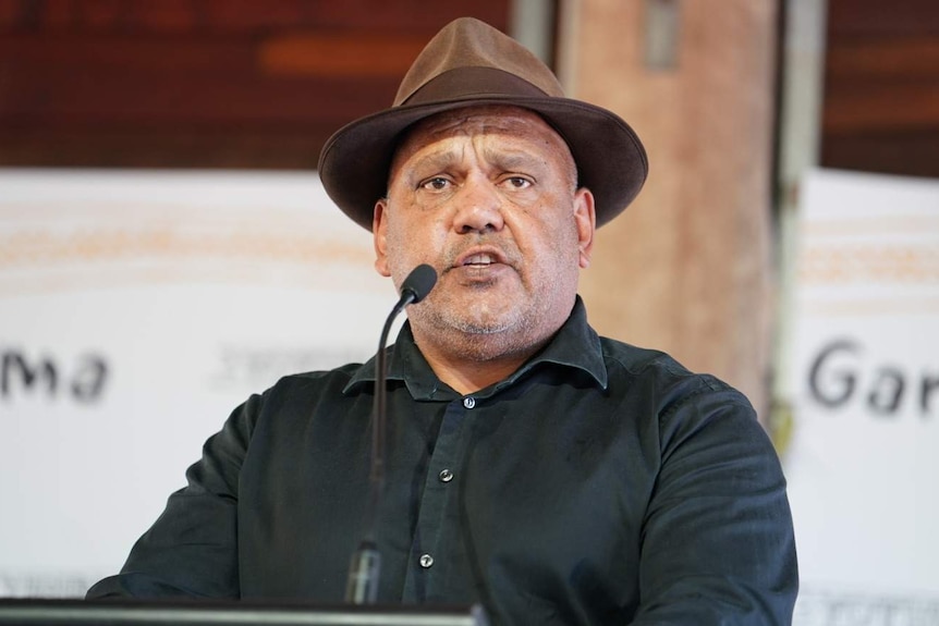 Noel Pearson, wearing a brown hat, speaks at a lectern at a Garma Festival in north-east Arnhem Land.
