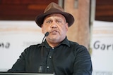 Noel Pearson, wearing a brown hat, speaks at a lectern