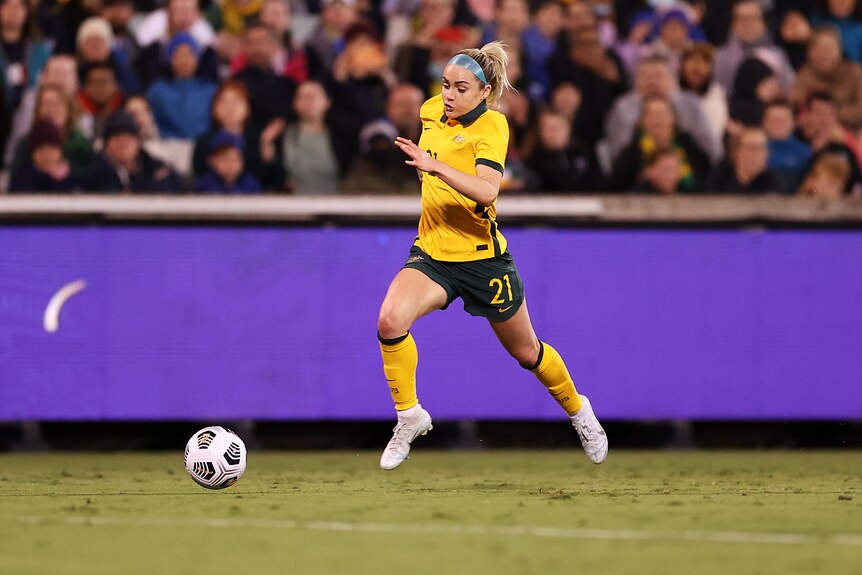 Ellie Carpenter runs with the ball at her feet
